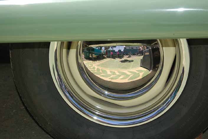 This image shows an example of vintage trailer wheels painted cream yellow, with chrome hubcaps and beauty rings