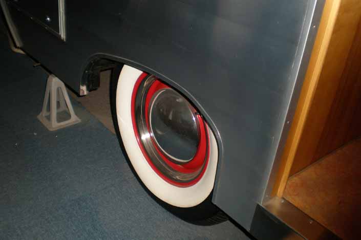 This example shows what vintage trailer wheels painted red look like with chrome hubcaps, beauty rings and wide ww tires