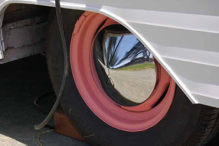 Photo shows an example of a vintage trailer with wheels painted pink and with pointy chrome hubcaps