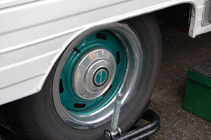 This example shows what vintage trailer wheels painted green look like with chrome hubcaps and beauty rings