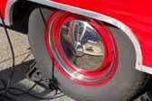 Image shows an example of nipple hubcaps on red wheels mounted on a vintage trailer