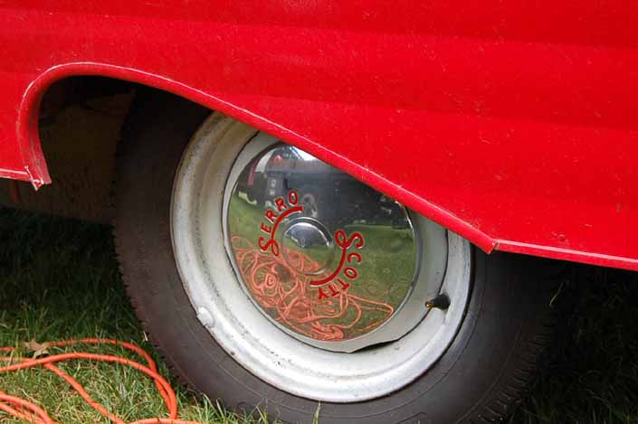 Photo shows an example of a vintage trailer with wheels painted white, with chrome hubcaps