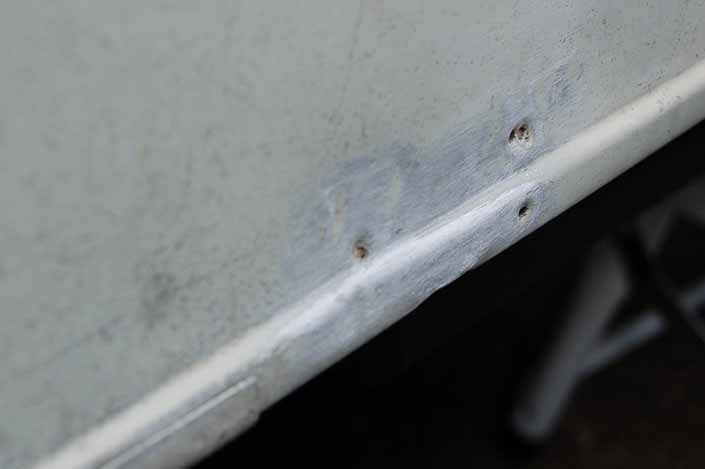 Photo shows ugly dents in vintage trailer aluminum siding that you can repair yourself