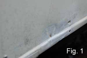 Image shows ugly dents and damage in a vintage camper trailers aluminum siding