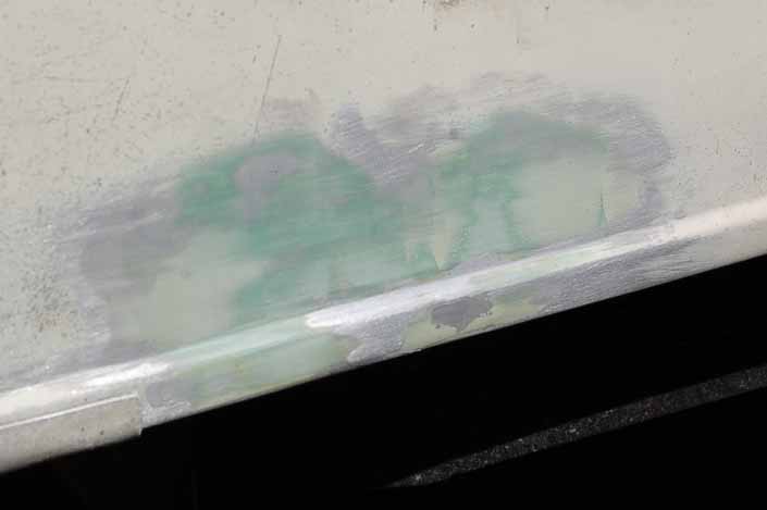 Picture shows repaired dents in a vintage camper trailer before paint and primer