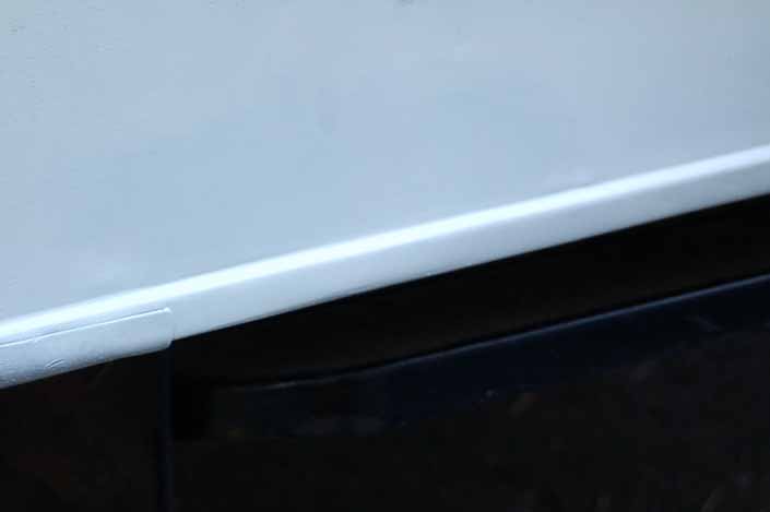 Picture of a repaired dent in a vintage trailer after it was primed and painted