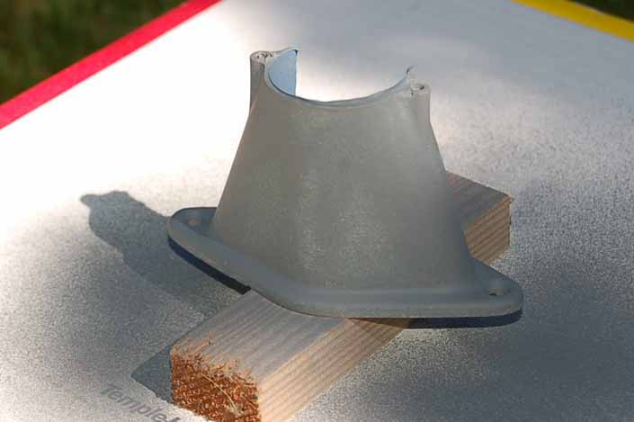 Photo shows how the first light coat of primer has been sprayed on the vintage trailer license plate lamp housing