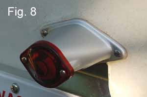 Picture of the vintage camper trailer license light after it has been painted, restored and installed back on the trailer with a new red light lens