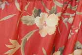 This photo shows a swatch of retro fabric with a tropical flowers pattern on a red background, for your vintage trailer