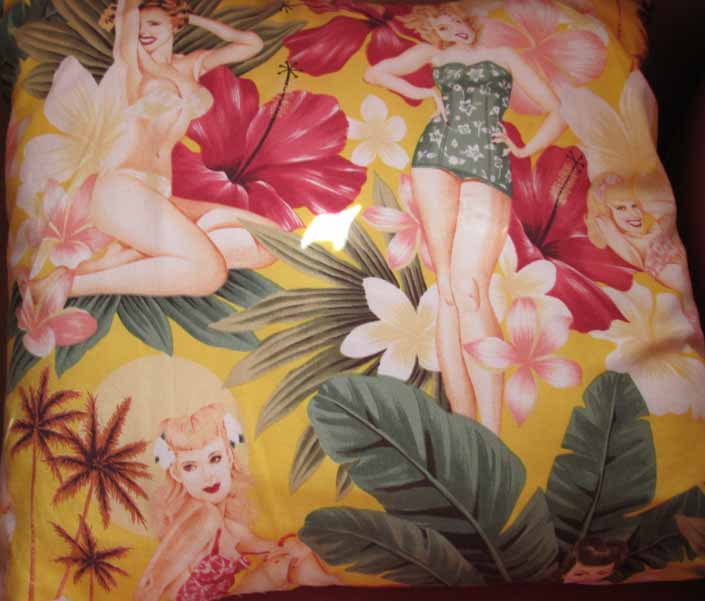 This photo shows a swatch of retro fabric with dreamy pinup girls in a tropical paradise, for your vintage trailer