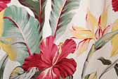 This photo shows a swatch of retro fabric with a hawaiian tropical flowers design on a white background, for your vintage trailer