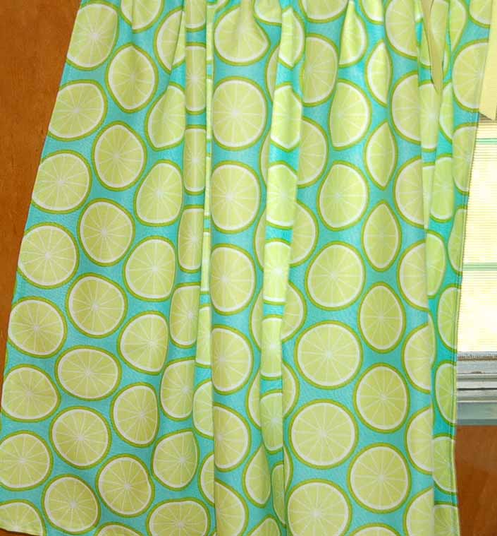 This photo shows a swatch of retro fabric with a 1960's colorful lemon slices design, for your vintage trailer
