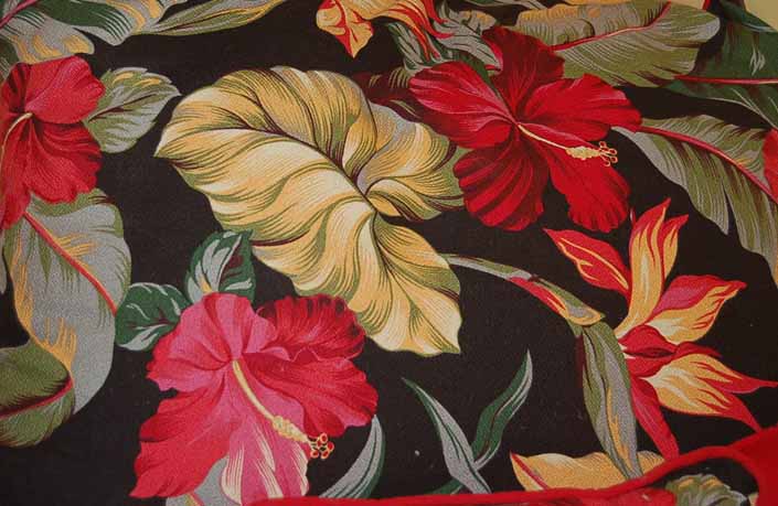 This photo shows a swatch of retro fabric with Hawaiian Flowers on a black background, for your vintage trailer