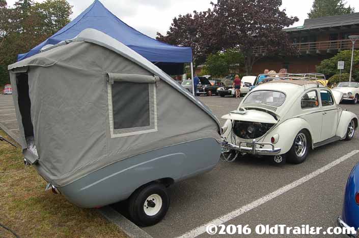 This vintage towing rig is a classic volkswagen bug pulling a compact fiberglass tent trailer