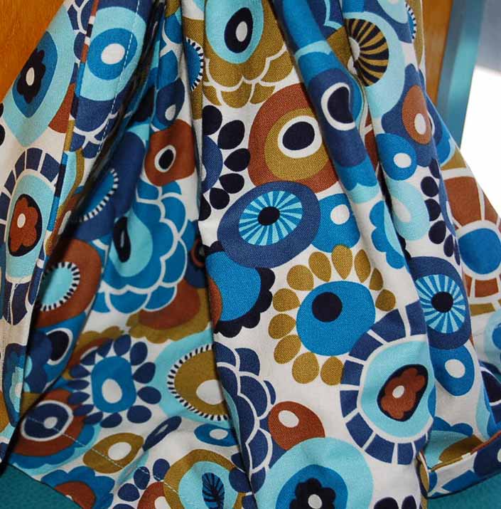 This photo shows a swatch of retro fabric with a 60's flower design for your vintage trailer