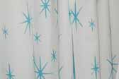 This photo shows a swatch of retro fabric with 60's Blue Starbursts on a White Background pattern, for your vintage trailer