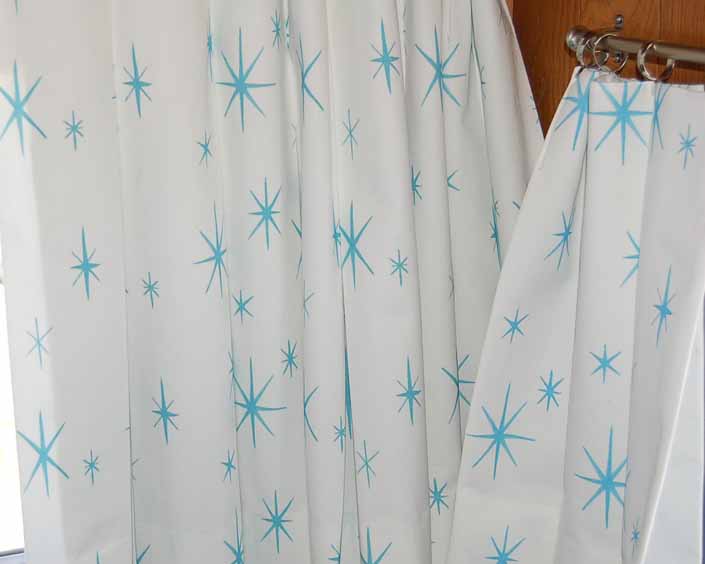 This photo shows a swatch of retro fabric with 60's Blue Starbursts on a White Background pattern, for your vintage trailer
