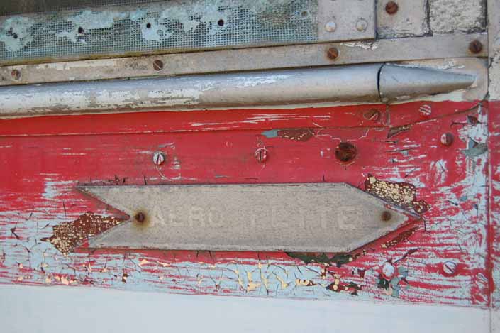 Original logo badge on the side of a rare vintage Aero Flite trailer in storage