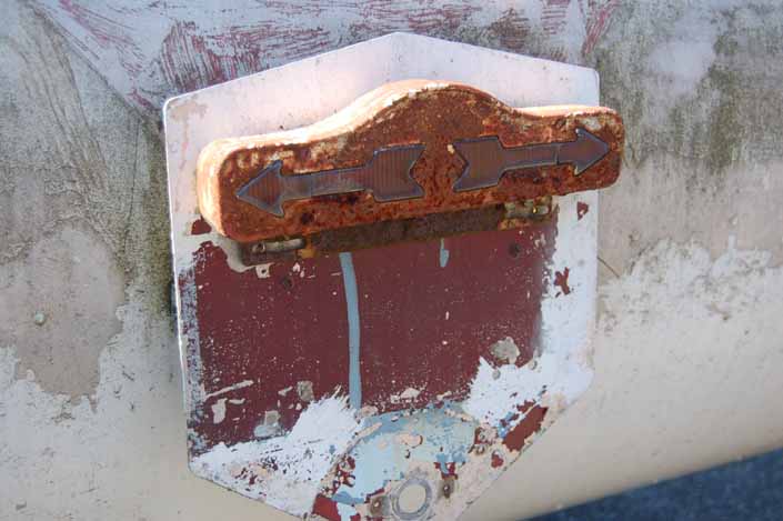 Unique turn signal plate still attached to the back of an original vintage Aero Flite trailer in storage