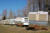 Pictures shows a row of classic Silver Streak trailers parked in a Vintage Trailer Storage-Yard