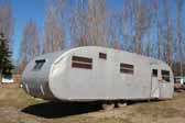 Vintage Spartanette travel trailer parked in a storage yard and perfect for restoration