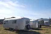 Picture of a group of vintage aluminum Airstream-style travel trailers in a trailer storage yard