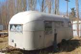 Photo of a vintage aircraft styled trailer stored in an old junkyard and ready to be restored
