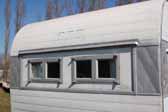 photo shows front windows replaced on an old Aloha trailer in a vintage ttrailer storage-yard