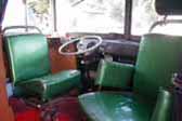 Roomy front cab in custom camper made out of a vintage volkswagen bus, has swiveling captains chairs and original vw dashboard